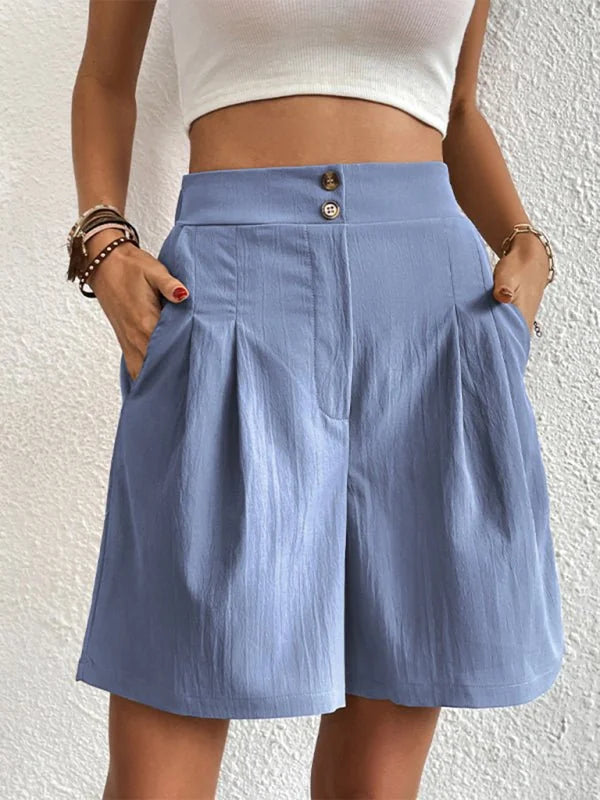 Light blue pleated shorts with button closure and textured fabric, worn by a model.