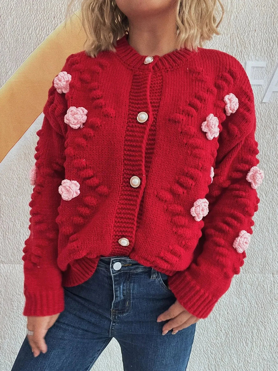 Red knit cardigan with embroidered pink flowers and pearl buttons.