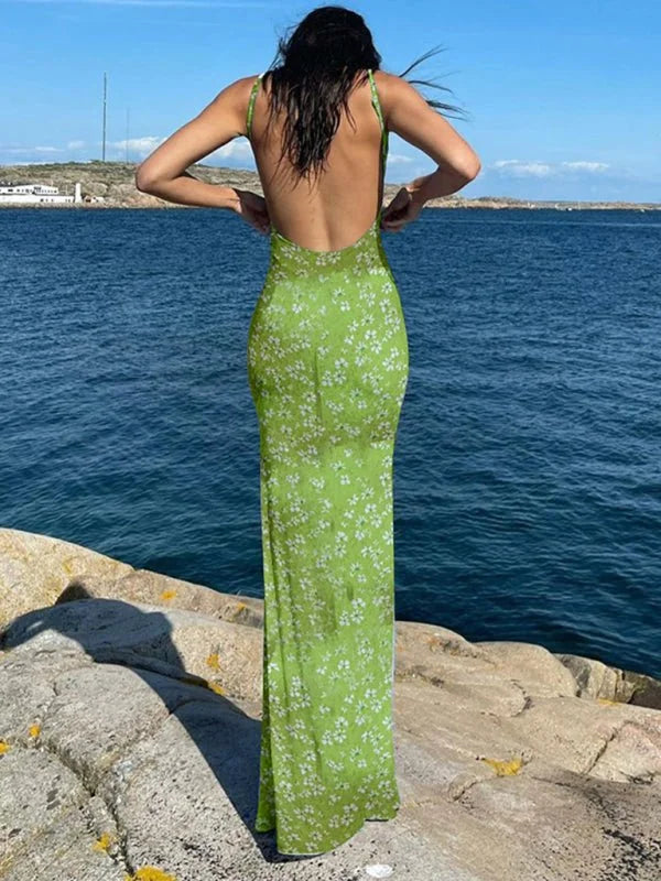 Lime green floral print maxi dress with a low back, worn by a model standing by the water.