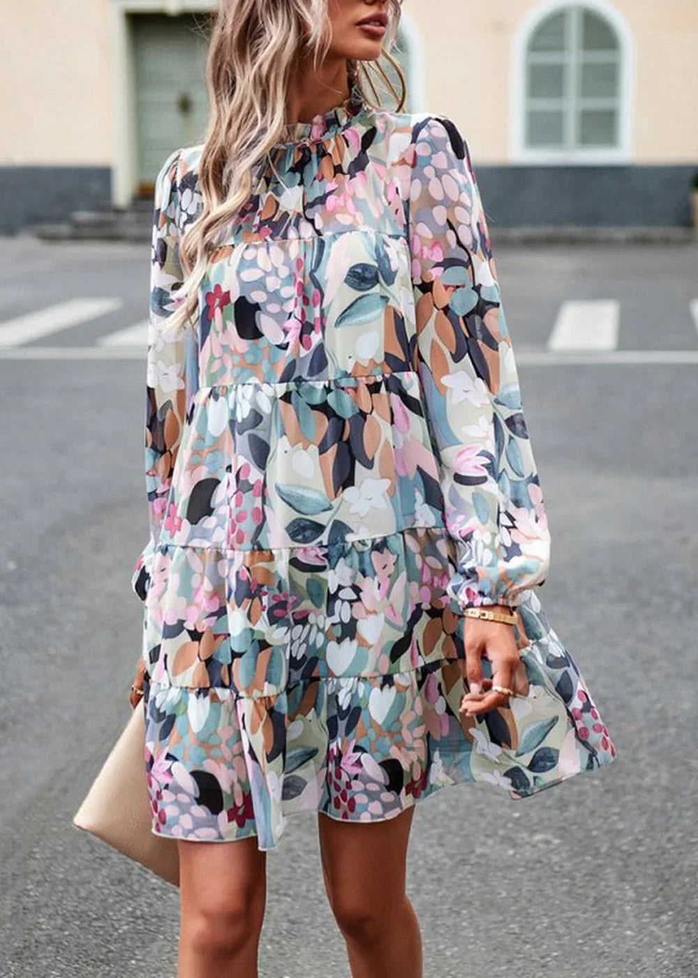 Tiered floral print dress with long sleeves and a mock neck, in pastel colors.
