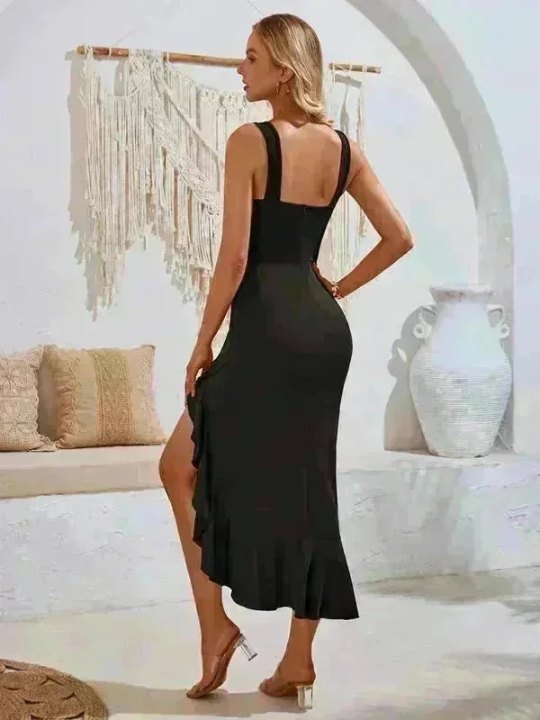 Black asymmetrical ruffle hem midi dress with a thigh-high slit, shown on a model.
