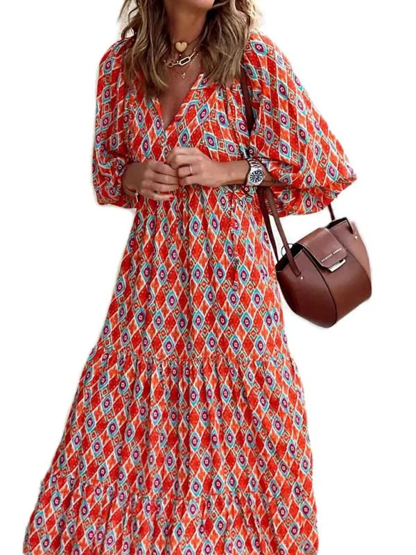 Orange maxi dress with geometric pattern, v-neck, and tiered skirt.