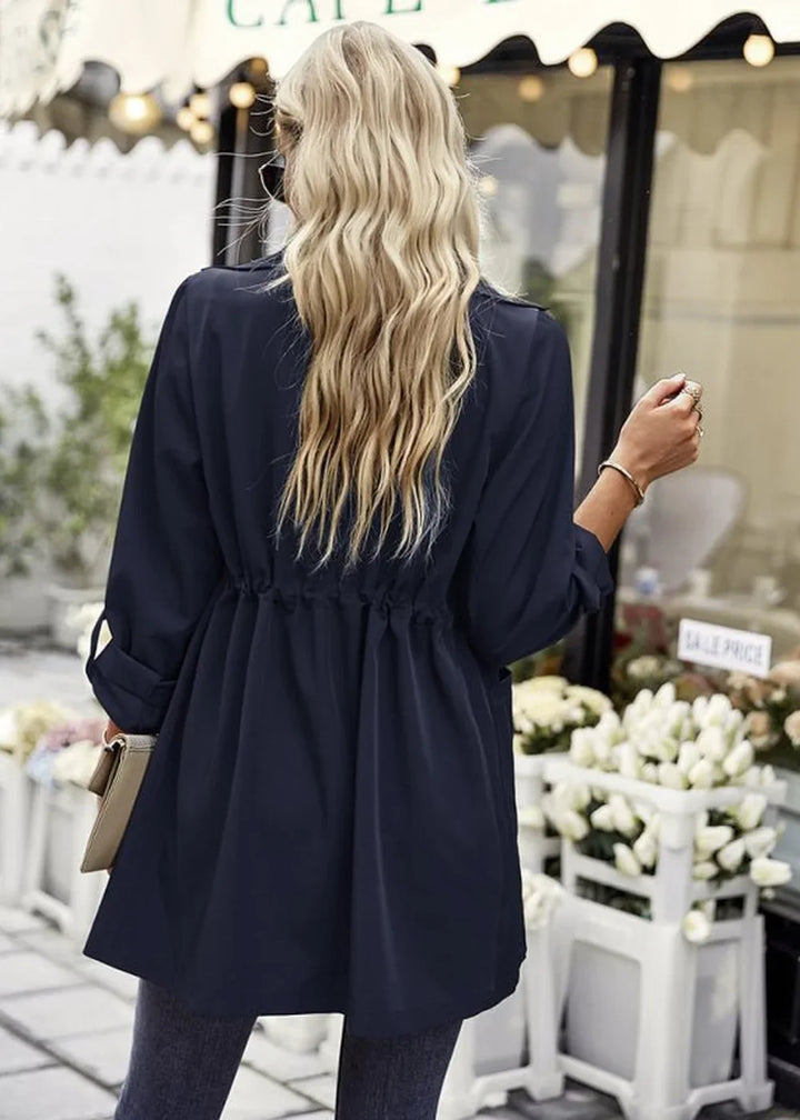 Navy blue cinched-waist trench coat with long sleeves, shown from the back.