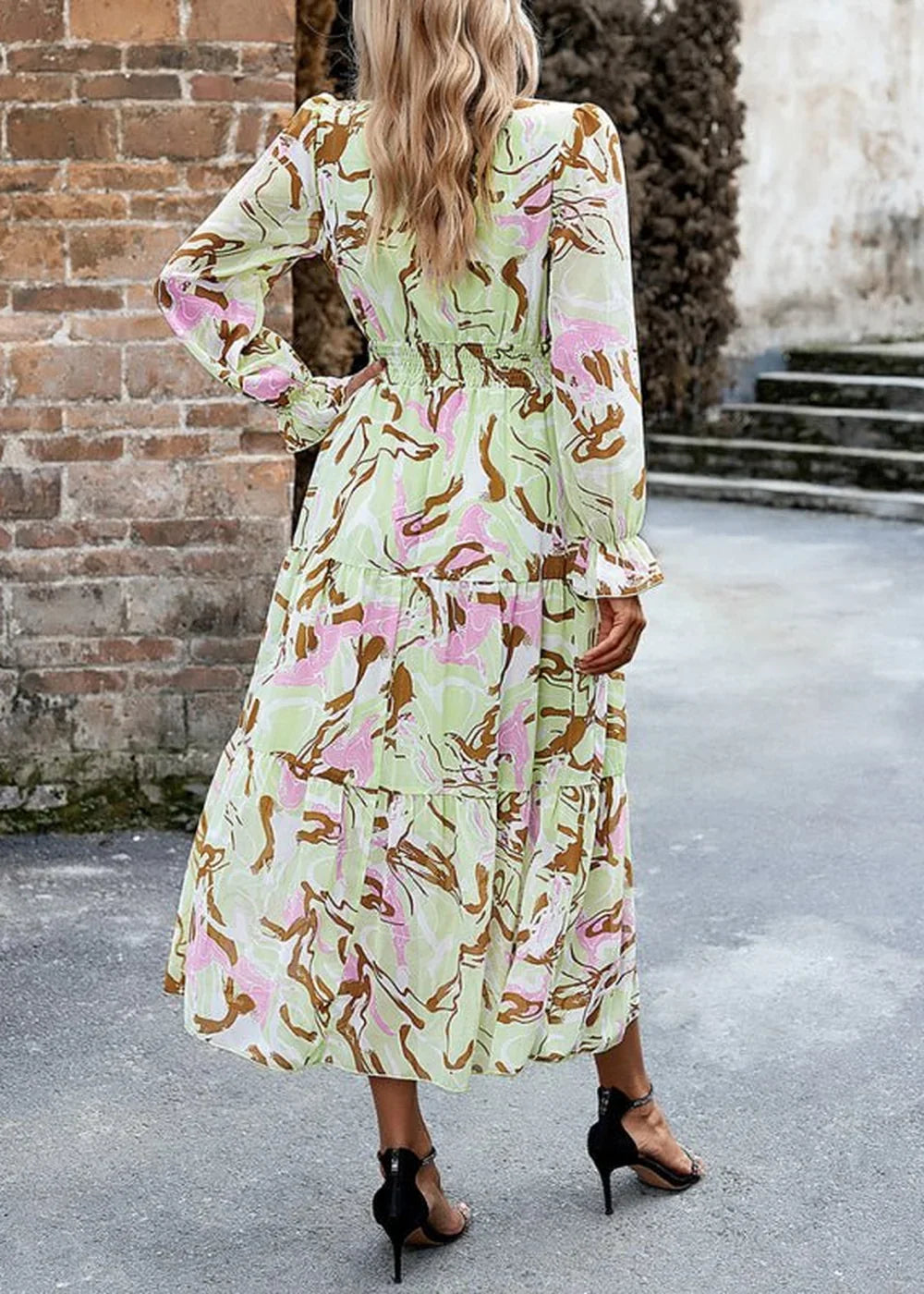 Maxi dress with abstract print in green, pink, and brown, featuring a smocked waist and tiered skirt.