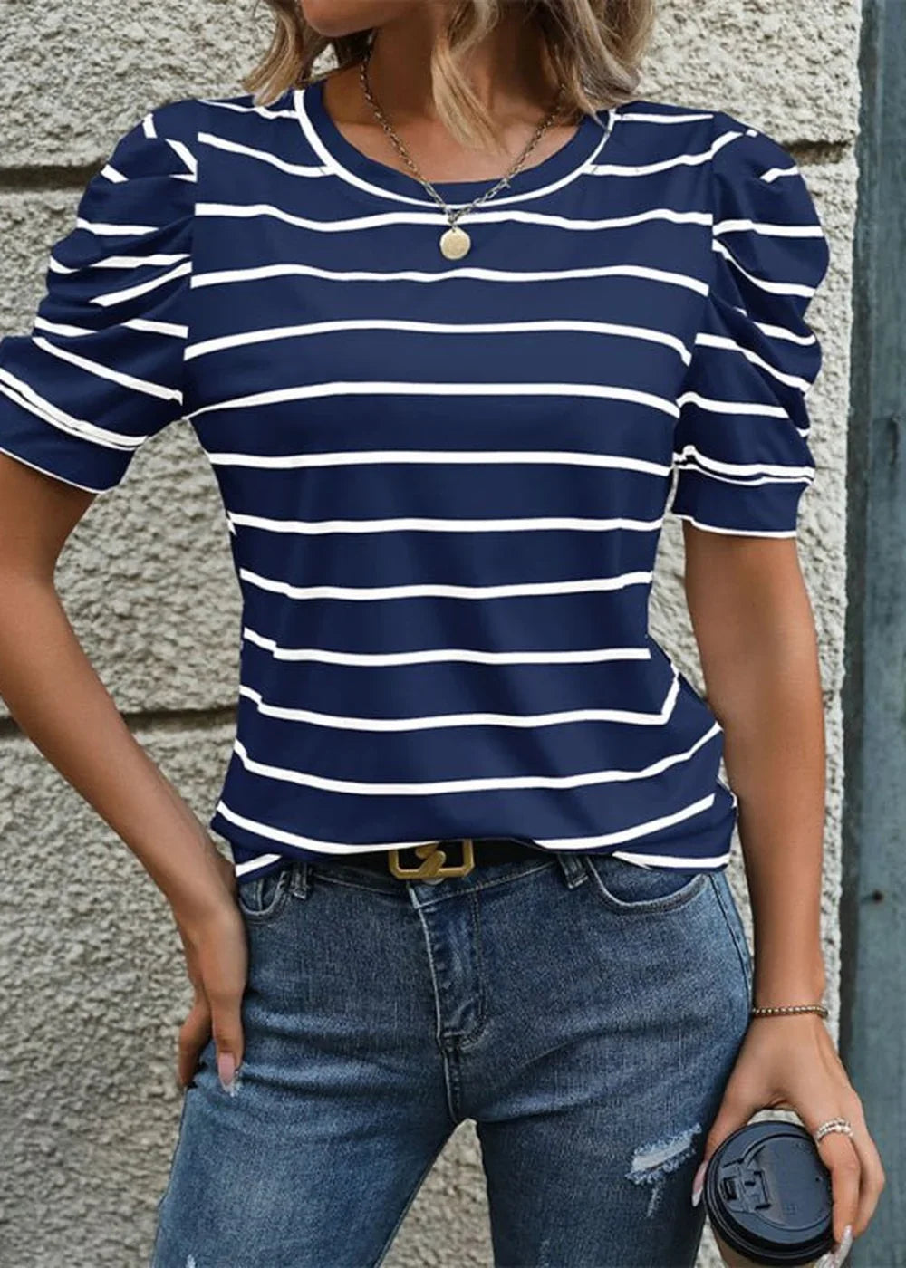 Navy blue and white striped puff sleeve top with a round neckline, paired with distressed denim jeans.