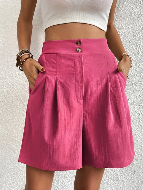 Bright pink textured shorts with a high waist and pleats, on model.