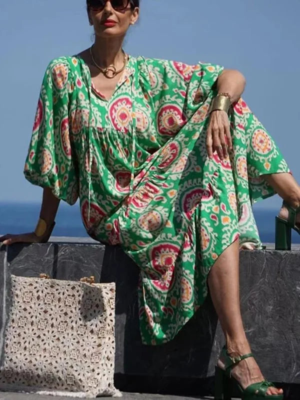 Green patterned maxi dress with a geometric design, flowy fit, and gold accessories.