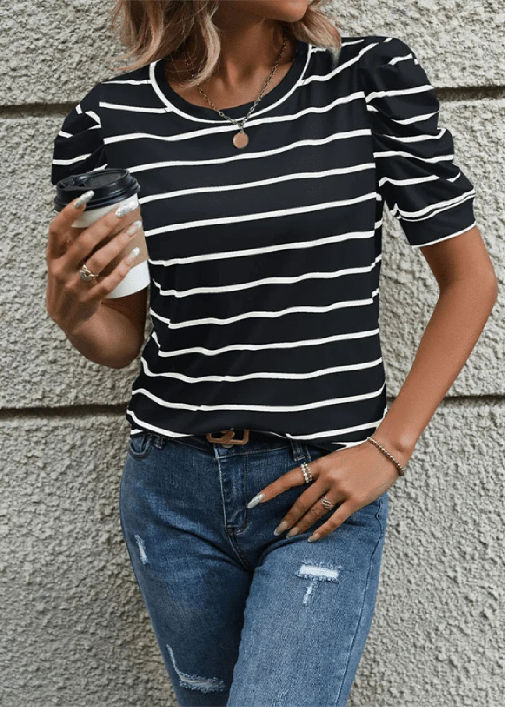 Black and white striped puff sleeve t-shirt with blue distressed denim jeans, worn by a model.
