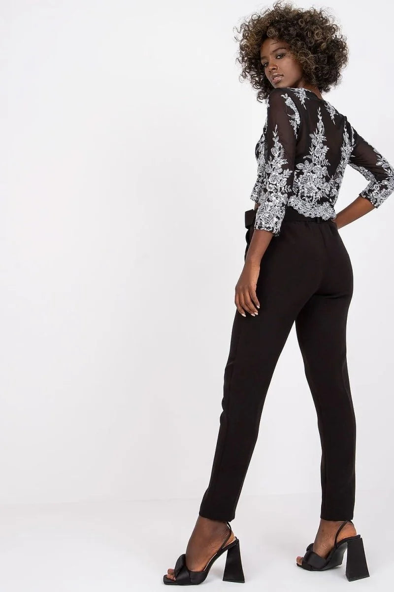 Black high-waisted pants with a belted waist, worn by a model on a white background.