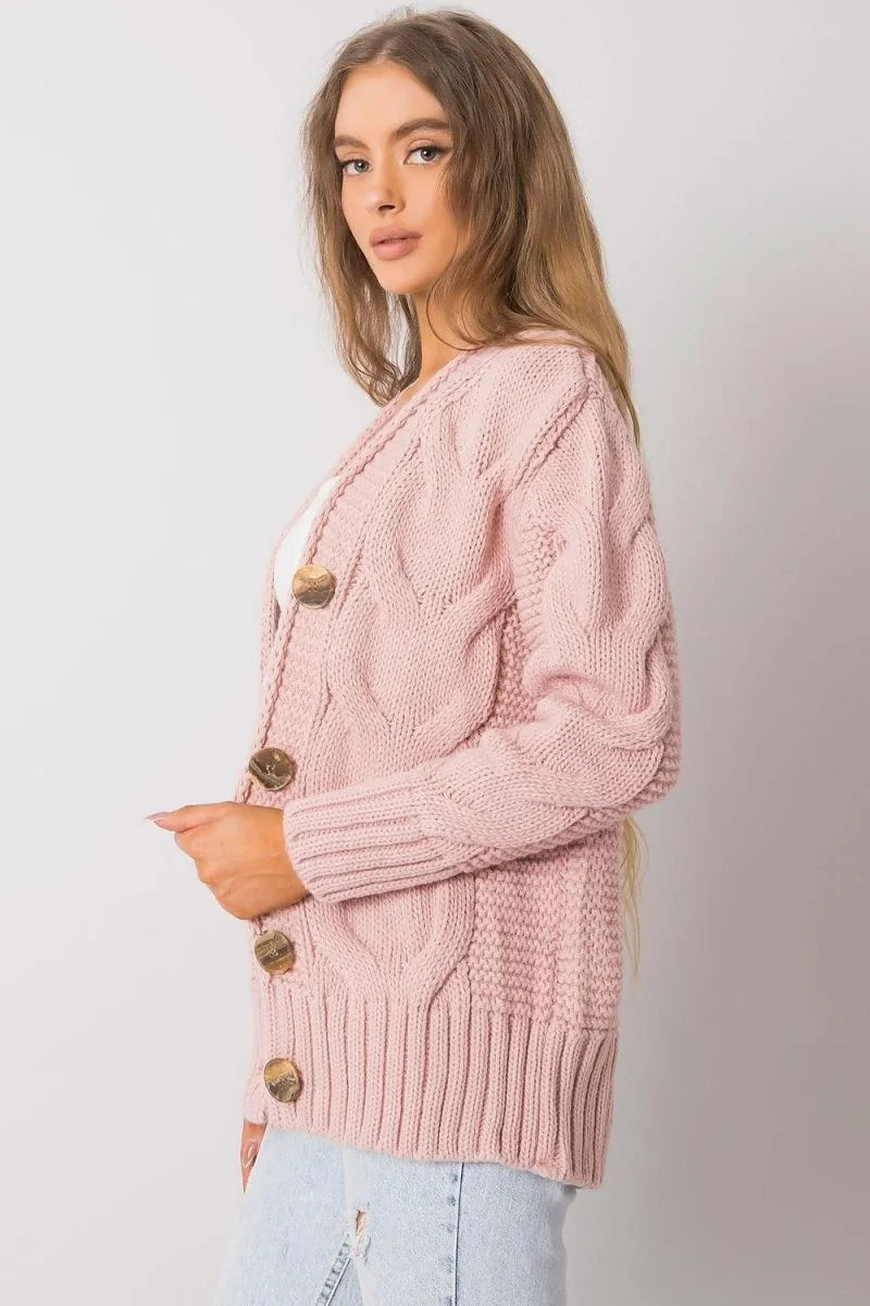 Pink cable-knit cardigan with wooden buttons, close-up of texture and ribbed hem