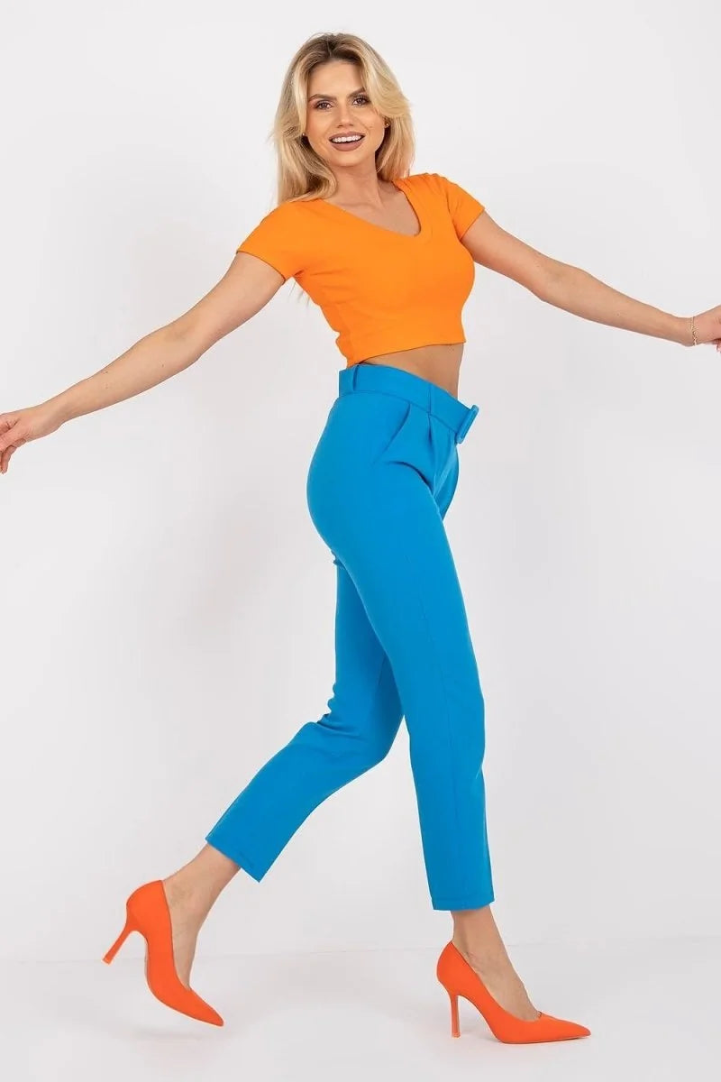 Bright blue high-waisted trousers with a pleated front and a matching belt, shown on a model.