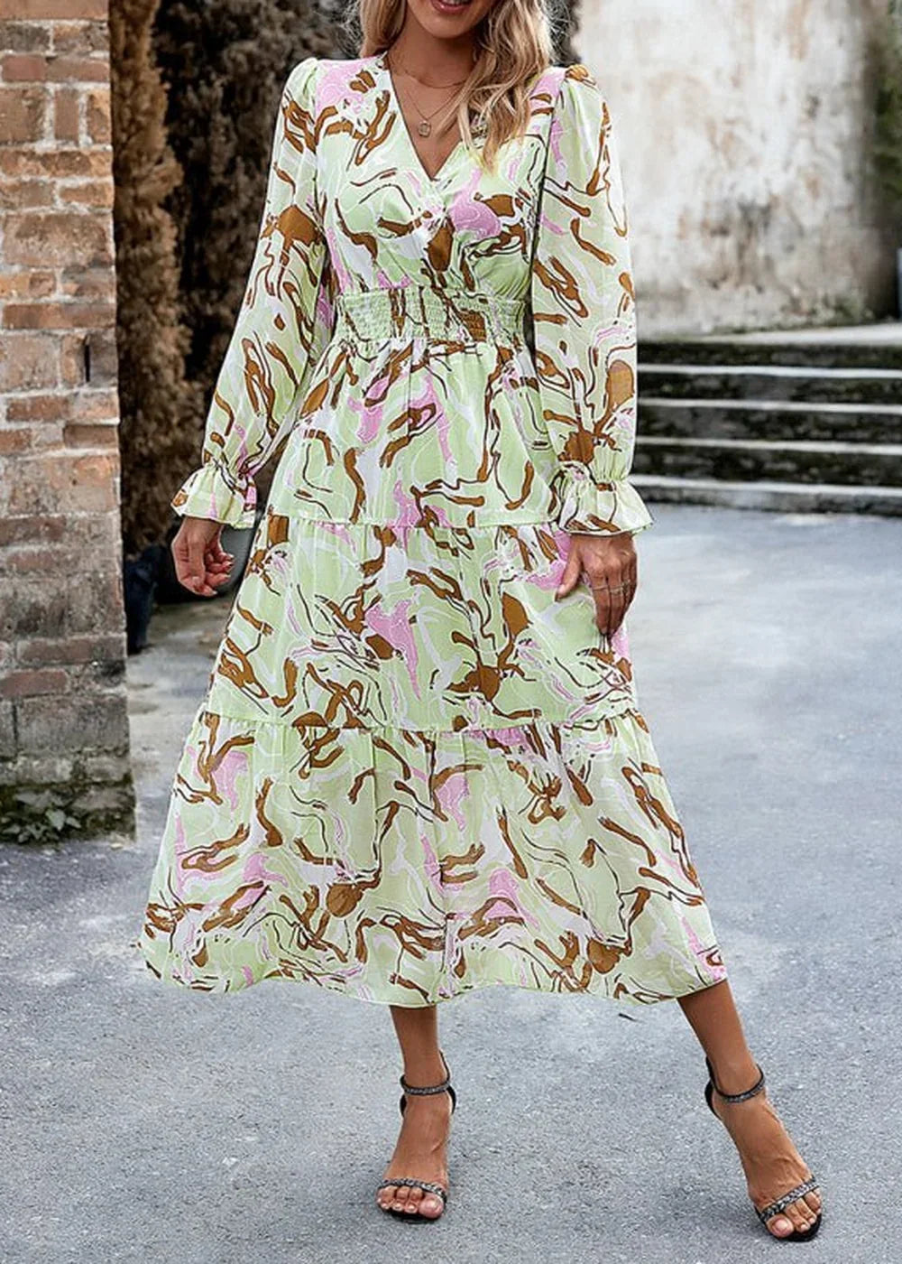 Light green midi dress with abstract print, V-neck, smocked waist, and tiered skirt.