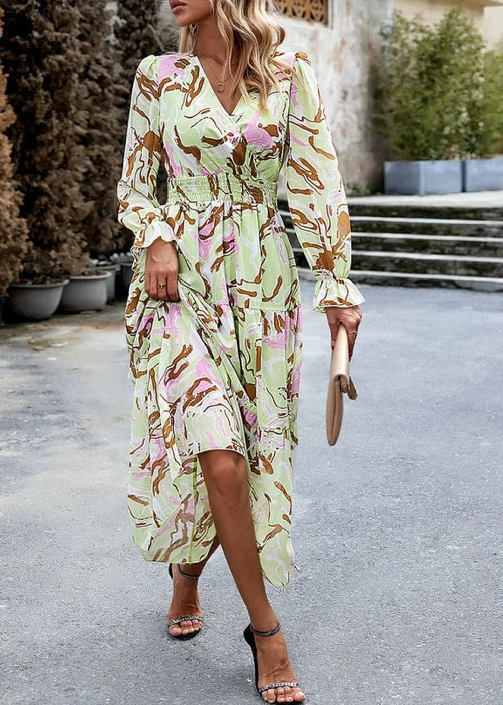 Light green maxi dress with abstract print, smocked waist, and ruffled cuffs on model.