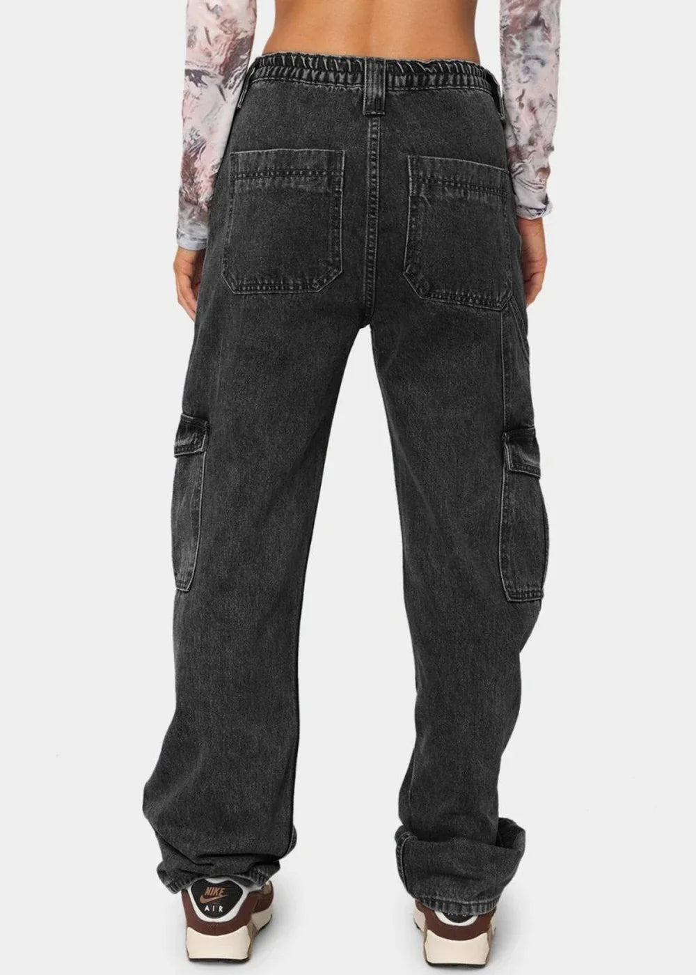 Black washed denim cargo pants with elastic waistband and large side pockets, shown from the back.