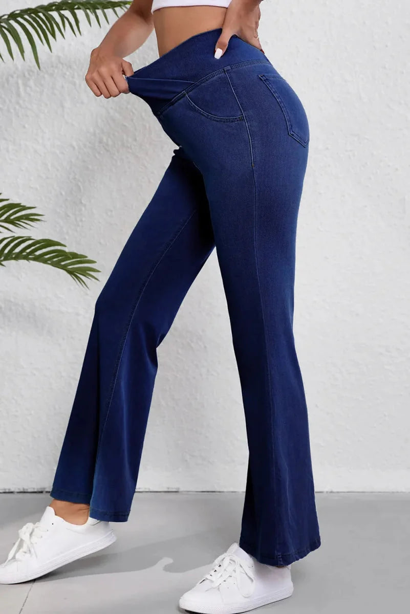 Medium wash denim pants with moderate stretch, featuring a flared leg and pocket details.