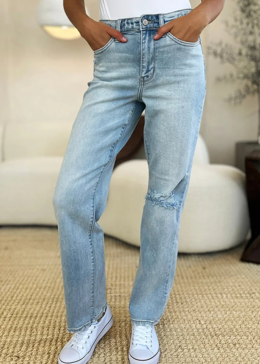 Close-up of distressed details on straight leg jeans