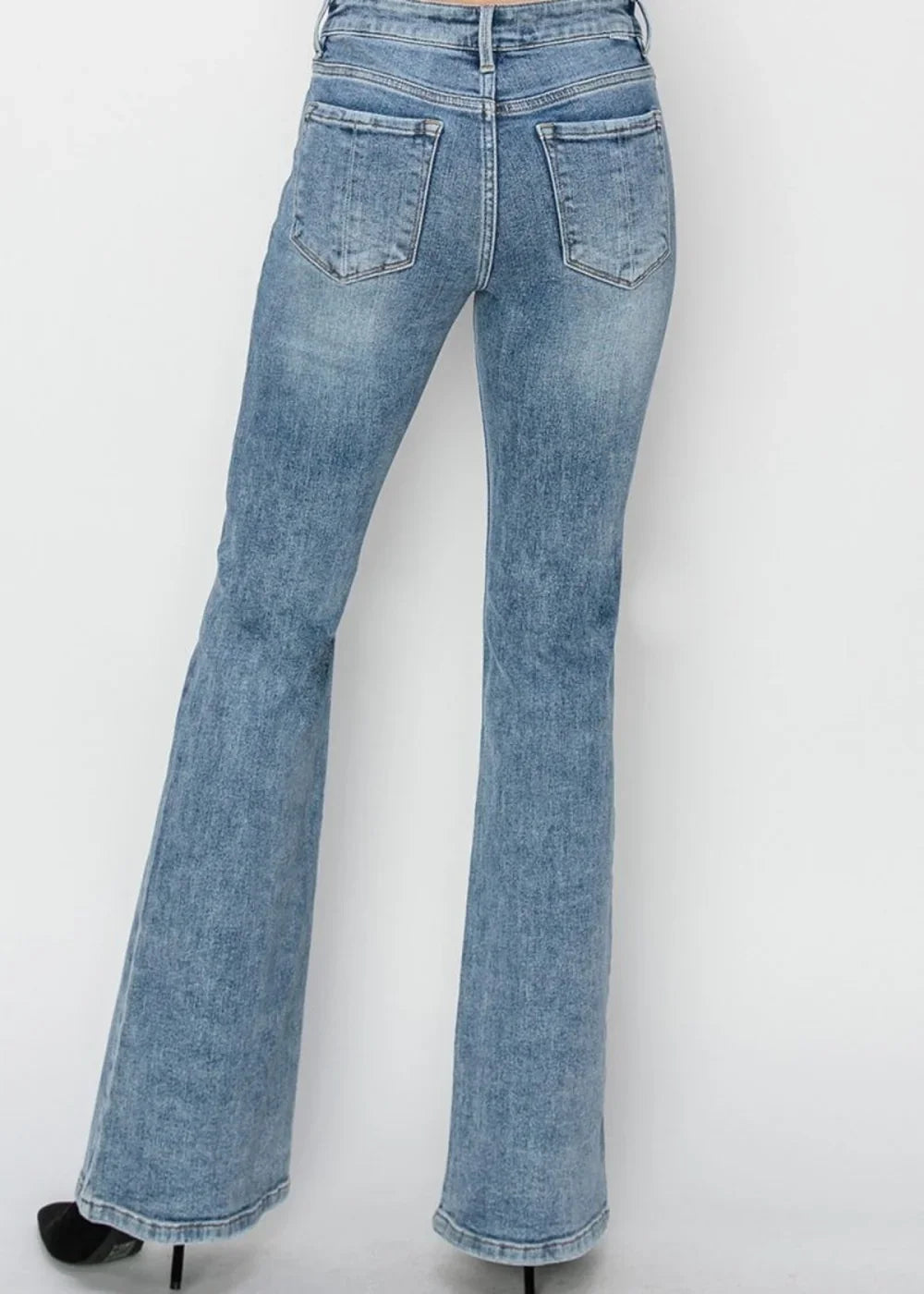 Back view of light wash distressed denim flare jeans with a regular fit.