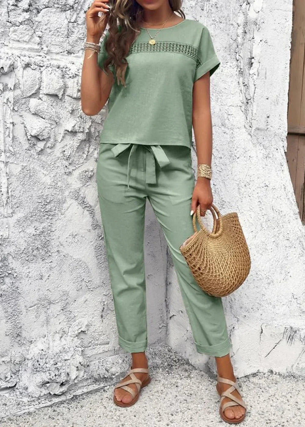 Sage green linen blend pant suit with cut-out detail on top and tie waist, worn by a model.