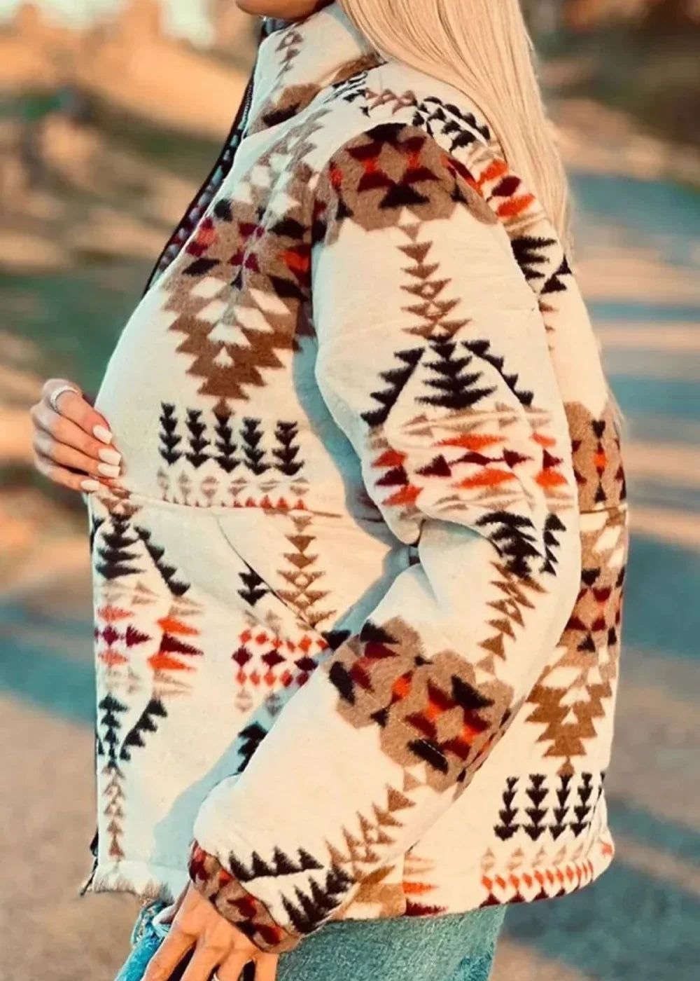 Cream jacket with geometric Southwestern pattern in brown, black, and rust orange, on model.