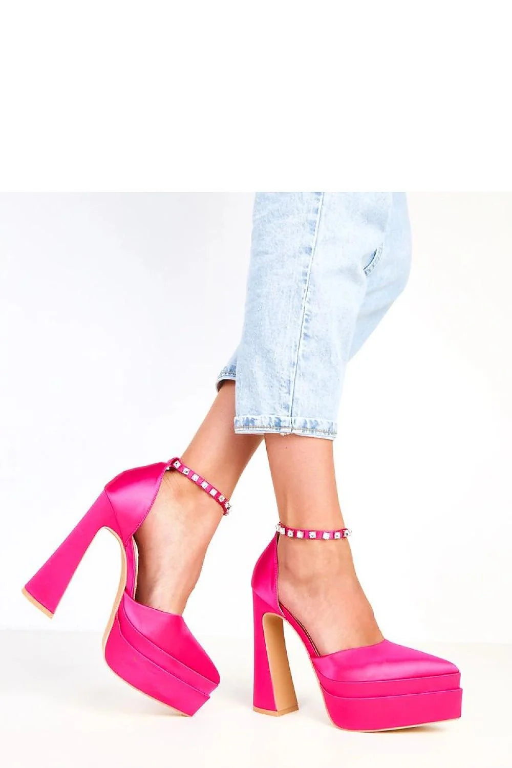 Hot pink satin platform heels with rhinestone ankle straps on a model.