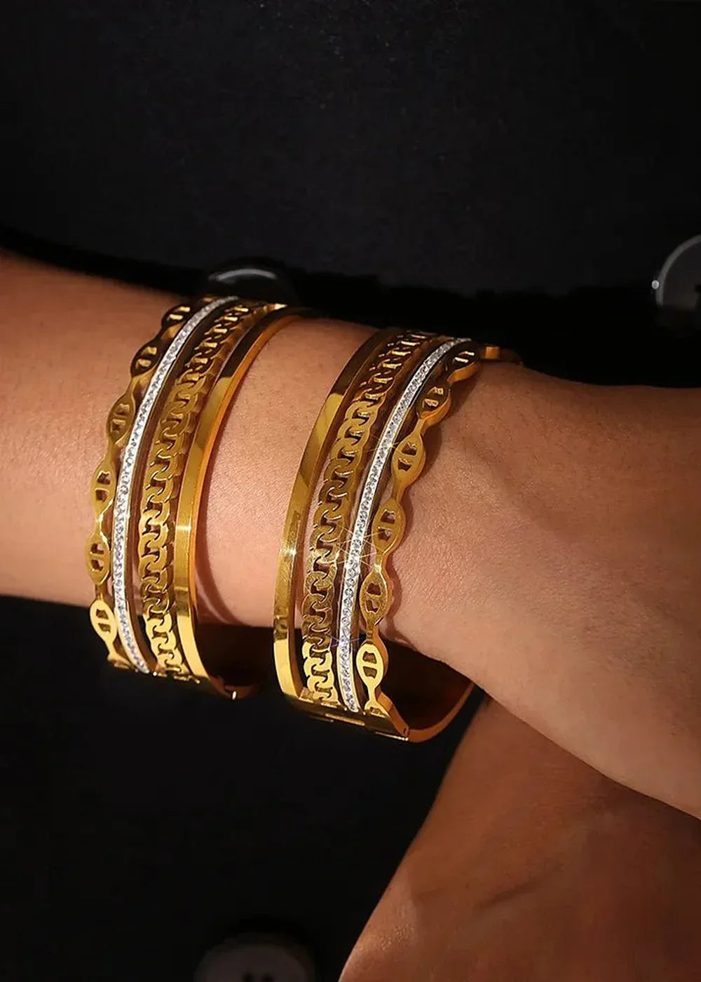 Gold-plated chain link bangles with sparkling Czech diamonds on a wrist.