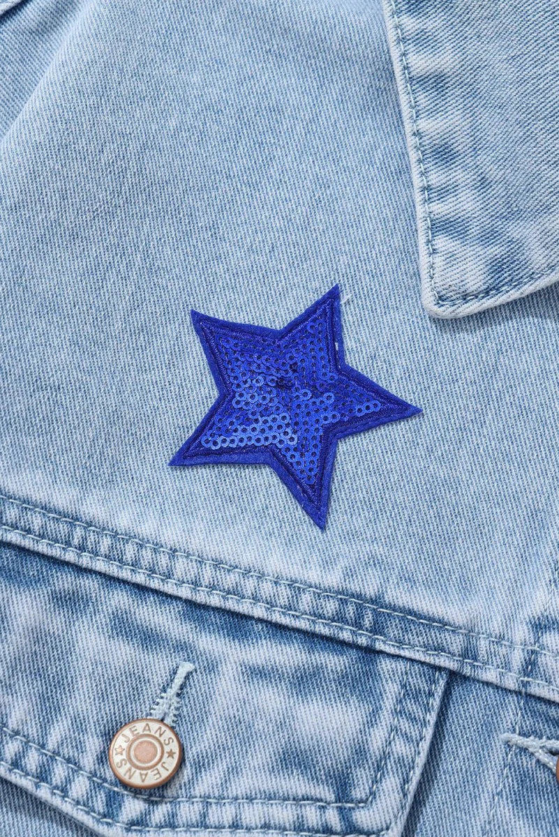 Light blue denim jacket with a bright blue sequined star patch and a branded button.