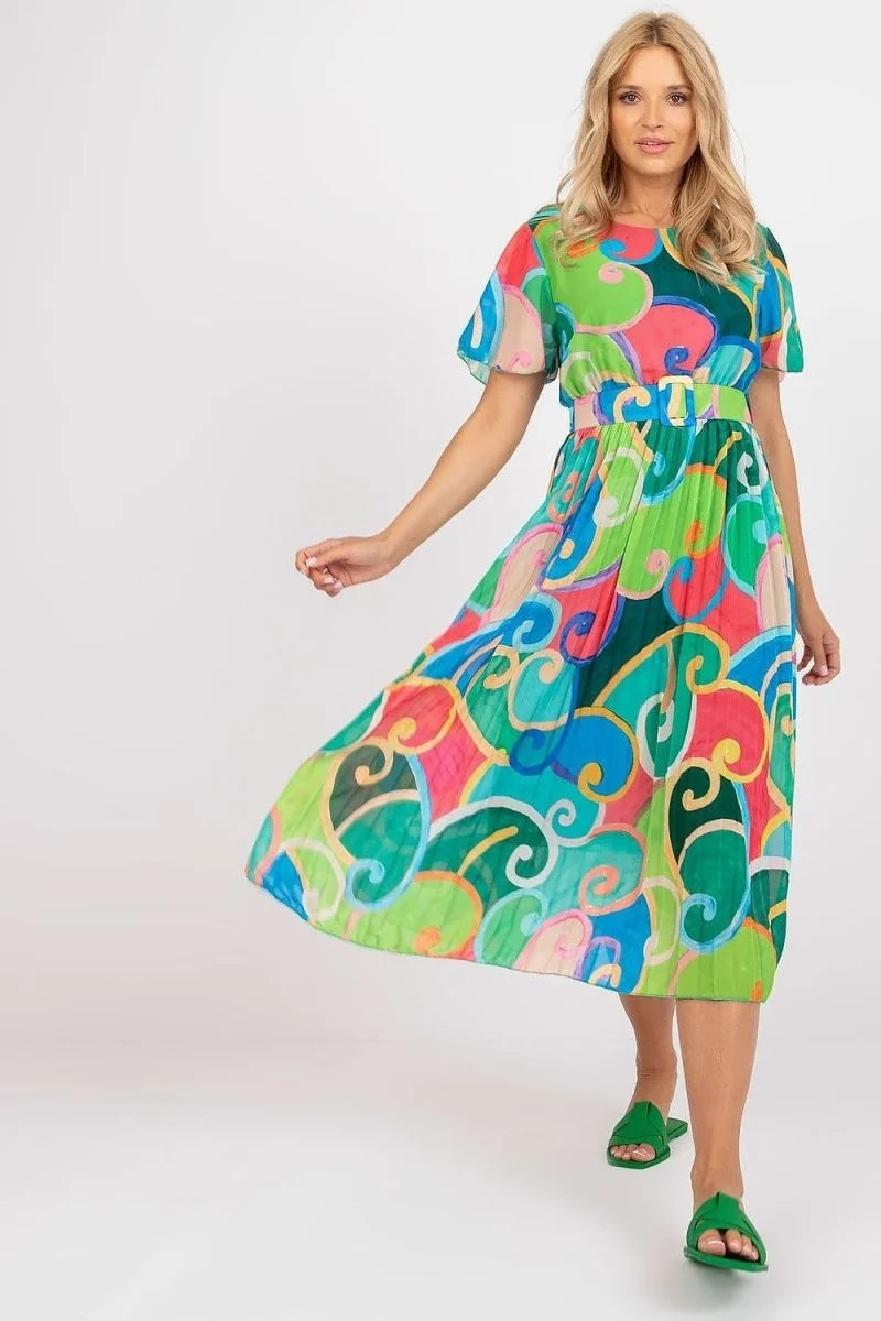 A woman in a vibrant, multi-colored swirl-print midi dress with flutter sleeves and a belted waist stands against a white ...