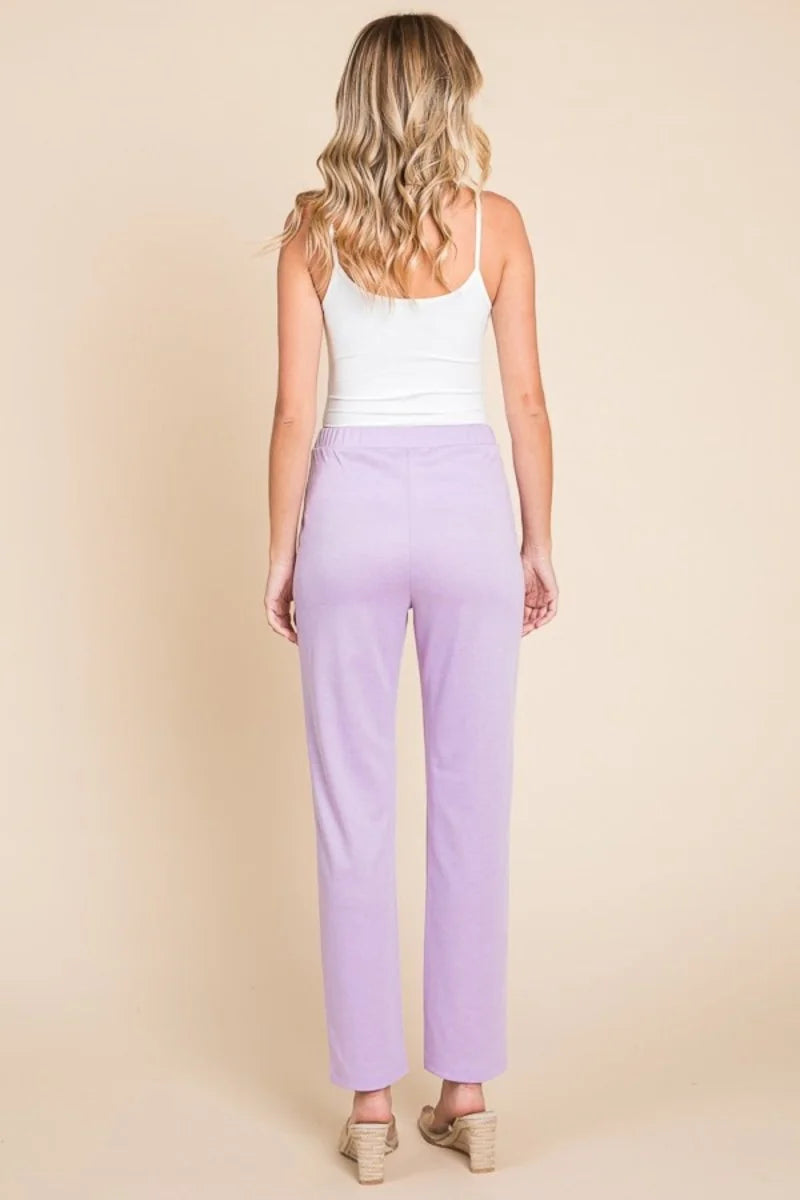 Back view of light purple slim-fit polyester and spandex pants on a model.