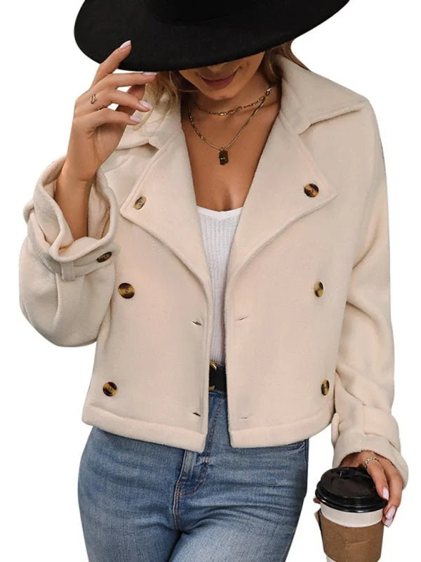 Cream double-breasted cropped jacket with gold buttons and rolled sleeves, worn by a model.