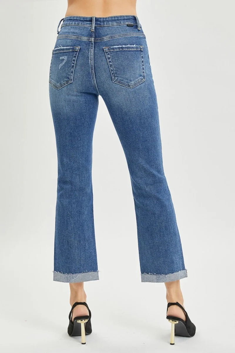 Medium wash distressed denim flare jeans with cuffed hem, shown from the back.