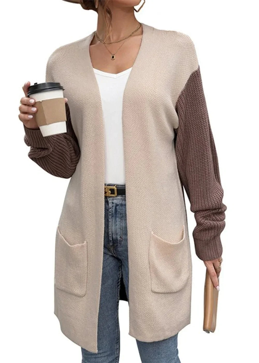 Two-tone knit cardigan in beige and brown with pockets and a coffee cup.