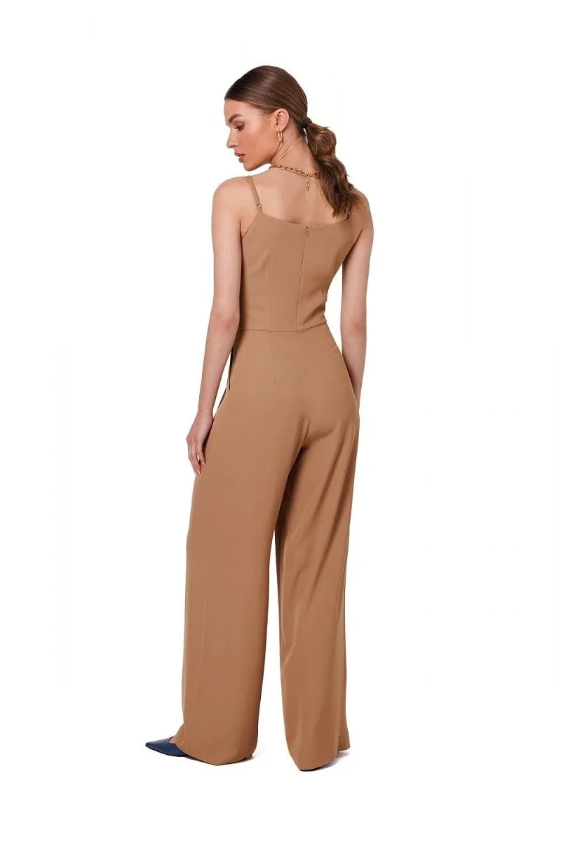 Back view of a woman wearing a tan, wide-leg jumpsuit with spaghetti straps.