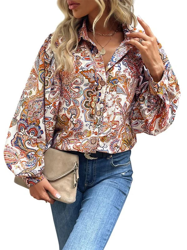 Woman wearing a loose-fit white blouse with a colorful paisley print and balloon sleeves.