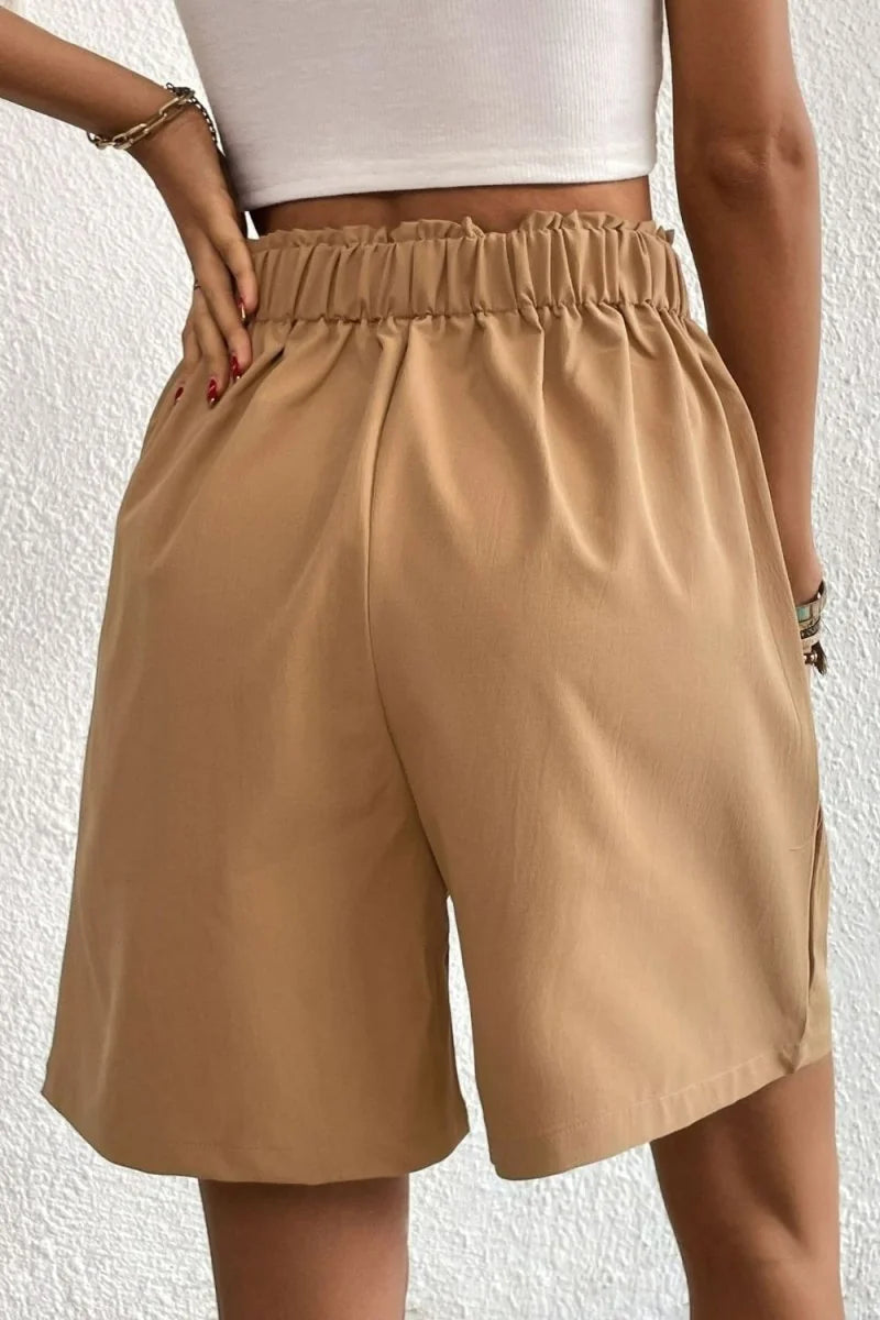 Back view of camel-colored shorts with elasticated paperbag waist on model