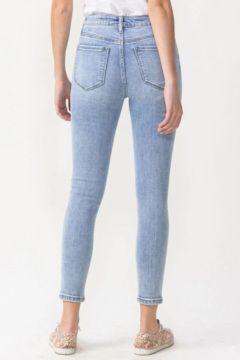 Light wash skinny jeans showing back pockets and ankle hem.