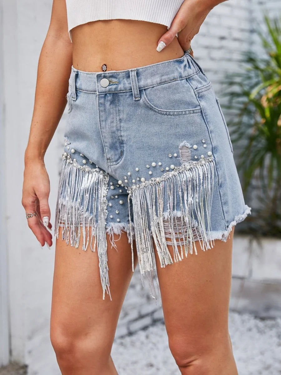 Close-up of pearl trim on denim shorts