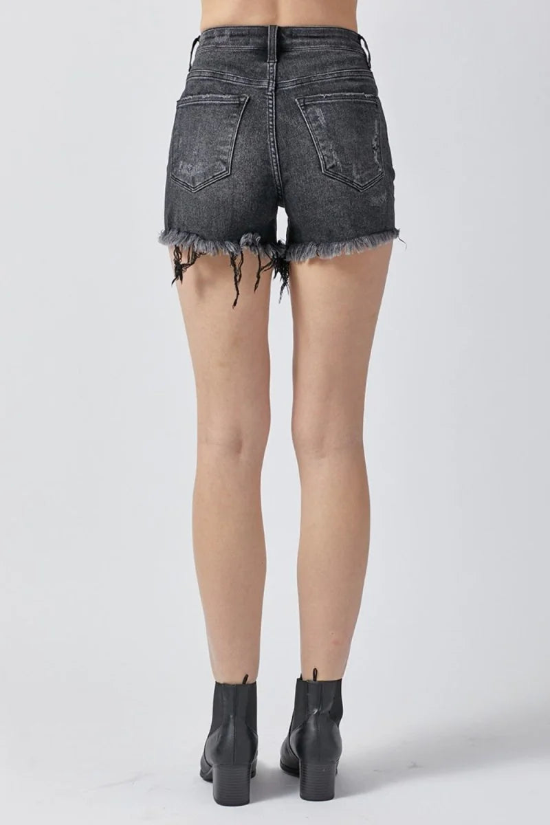 Close-up of raw hem detail on denim shorts