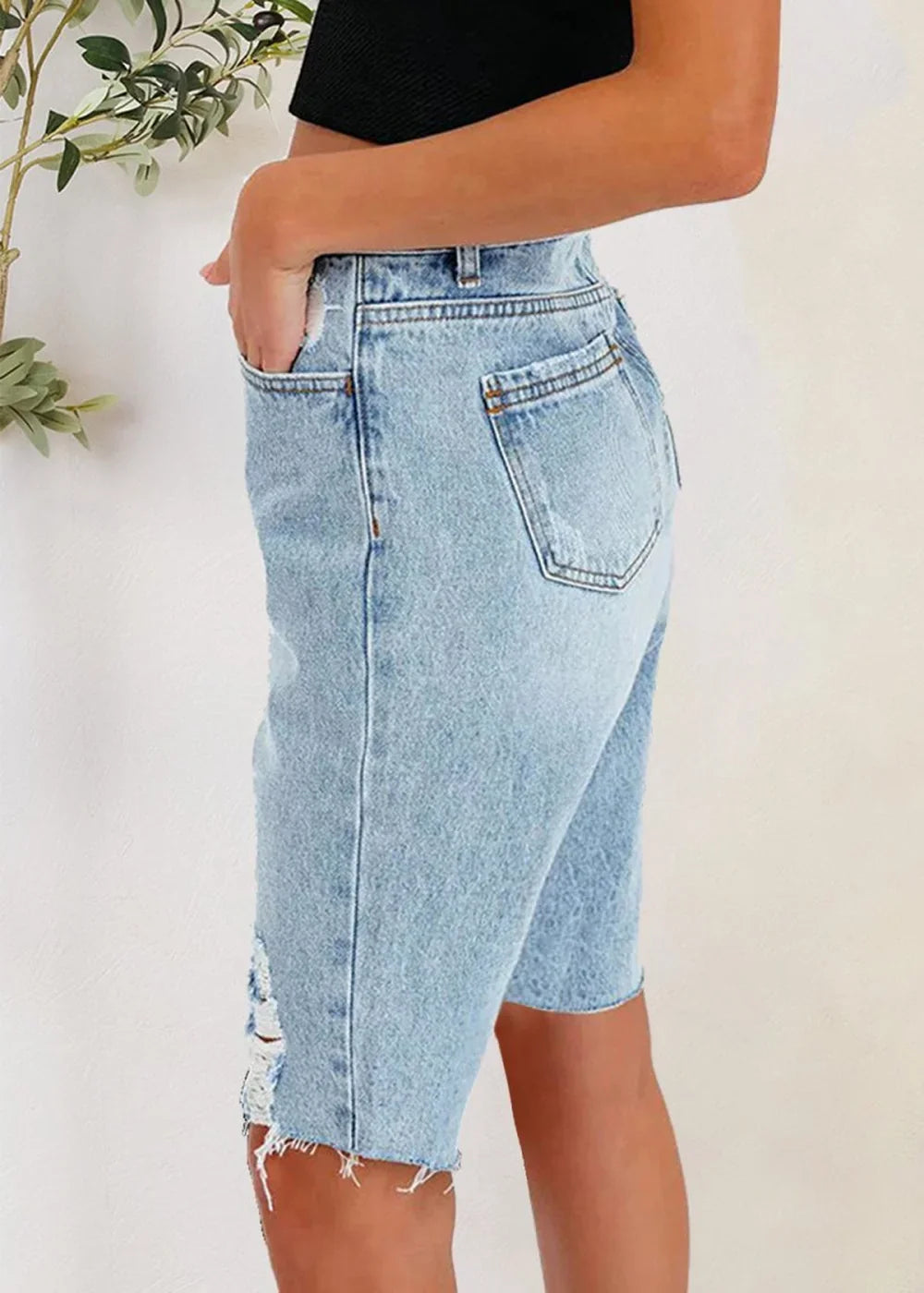 Close-up of distressed detail on denim shorts