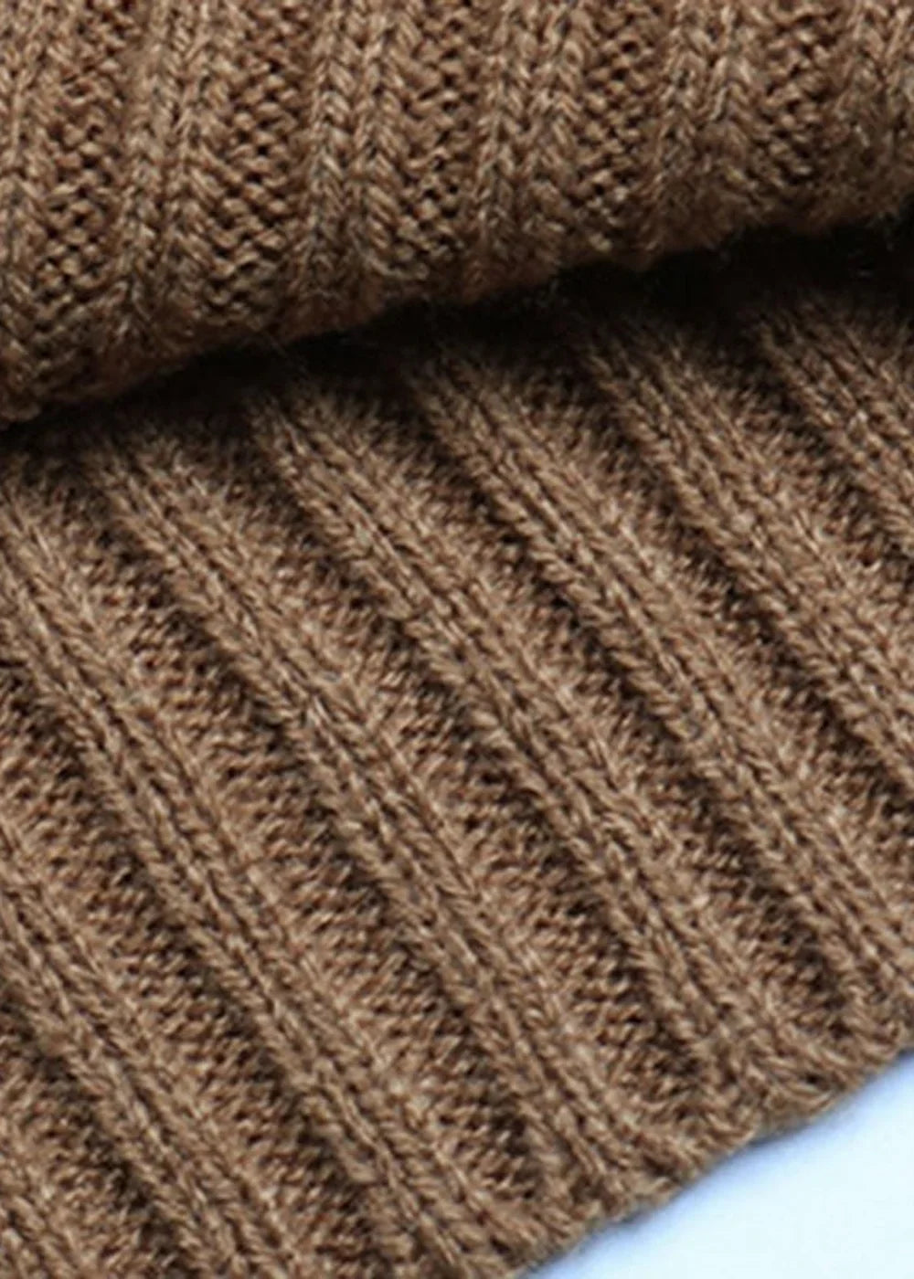 Close-up of a brown ribbed knit sweater dress, showing a textured polyester material with vertical ribbing.