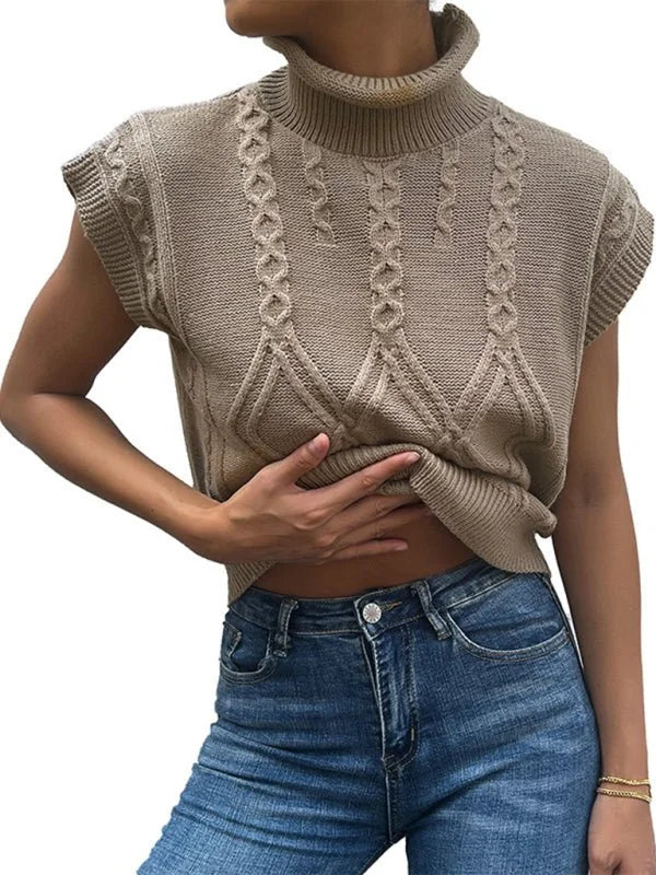 Close-up of a tan, cable-knit, sleeveless turtleneck sweater vest on a model.