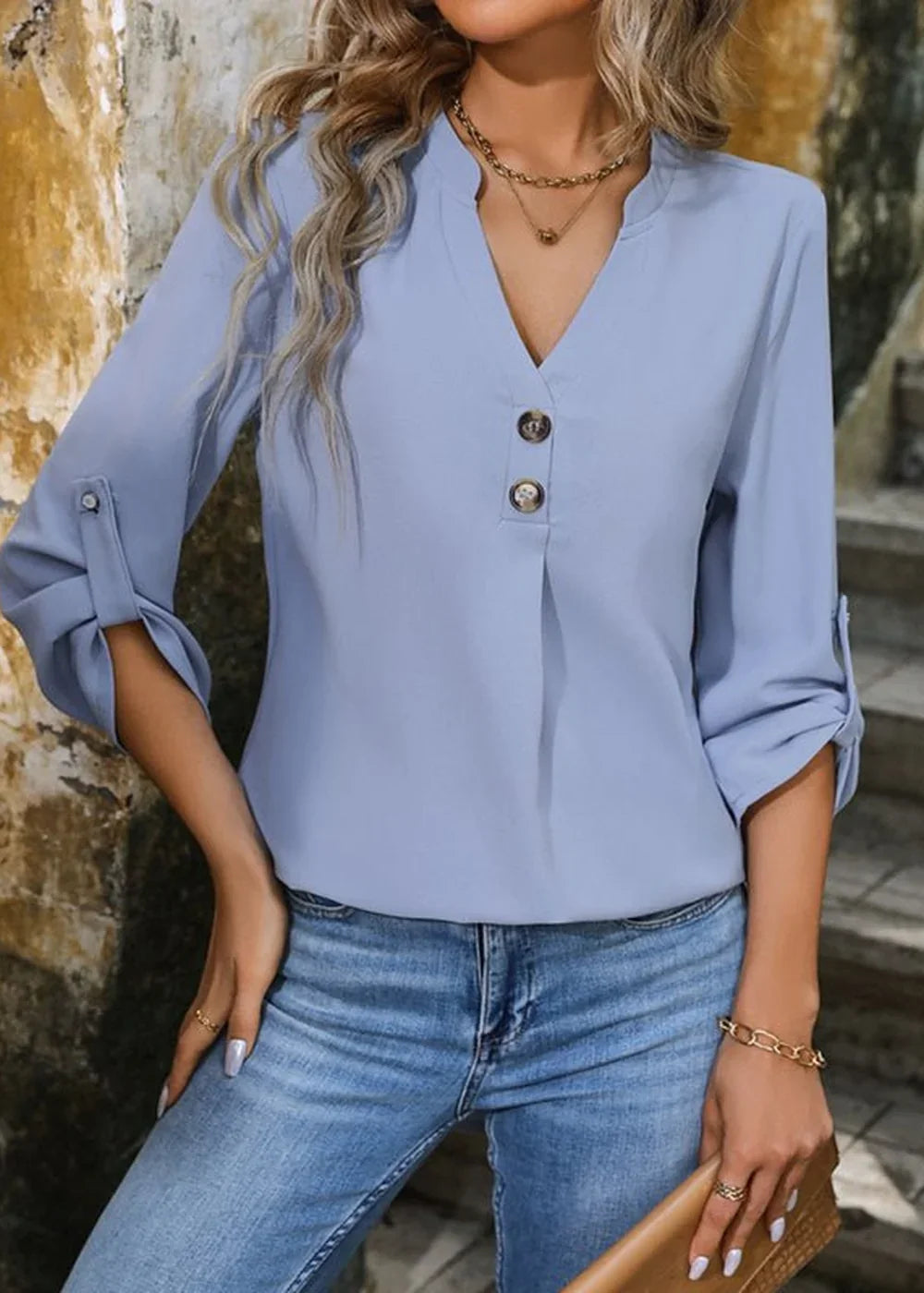 Light blue polyester blouse with a V-neck, button details, and rolled sleeves.