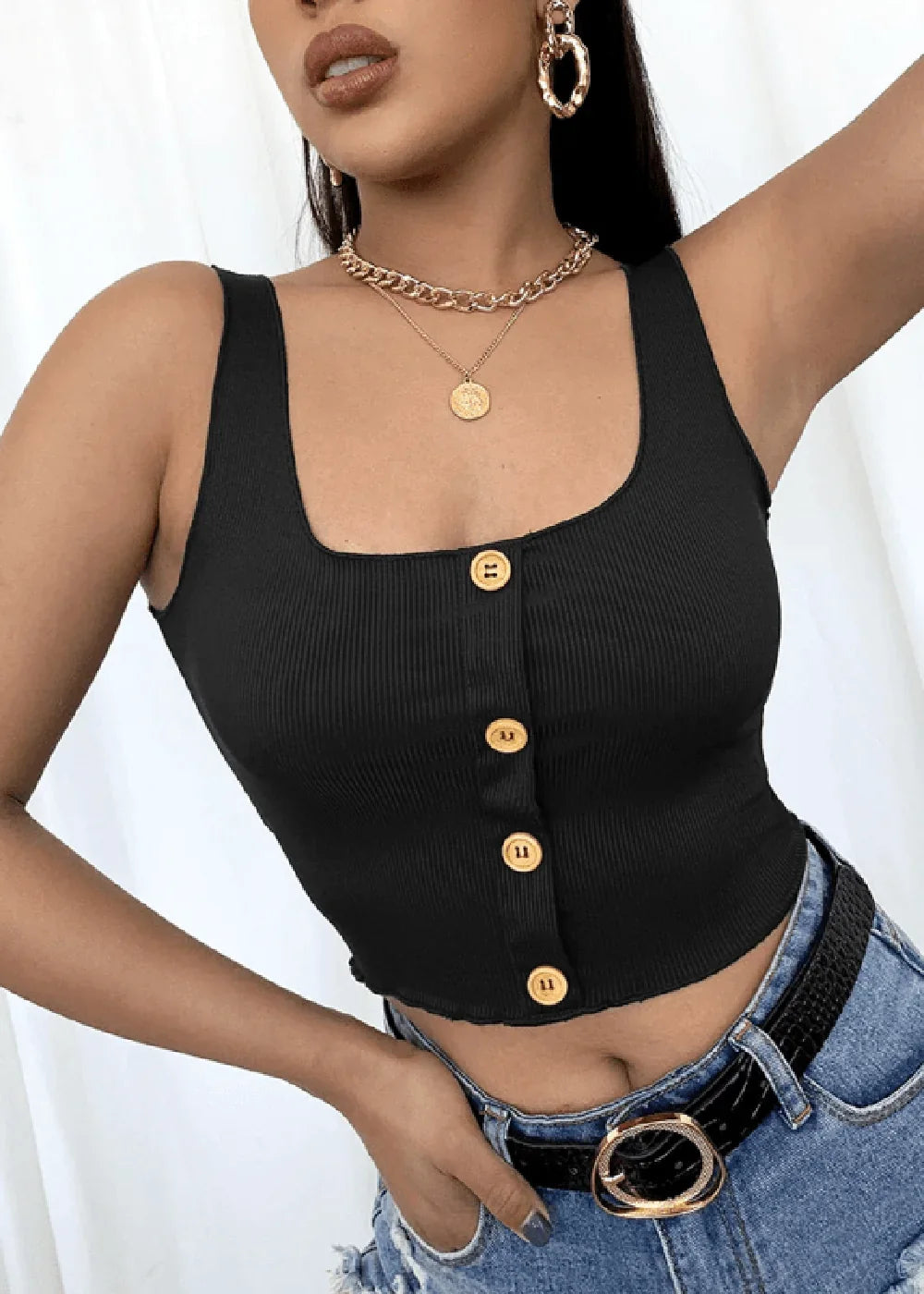 Close-up of a black ribbed knit tank top with gold buttons, paired with blue denim jeans and a black belt.