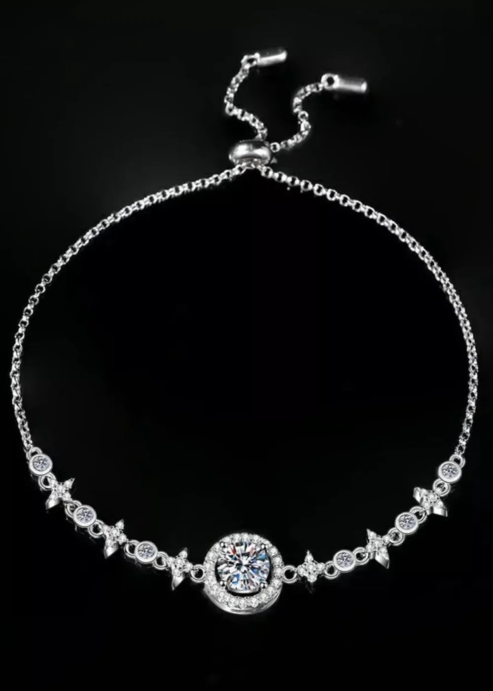 Silver-tone bolo bracelet with a central round-cut cubic zirconia and small starburst accents.
