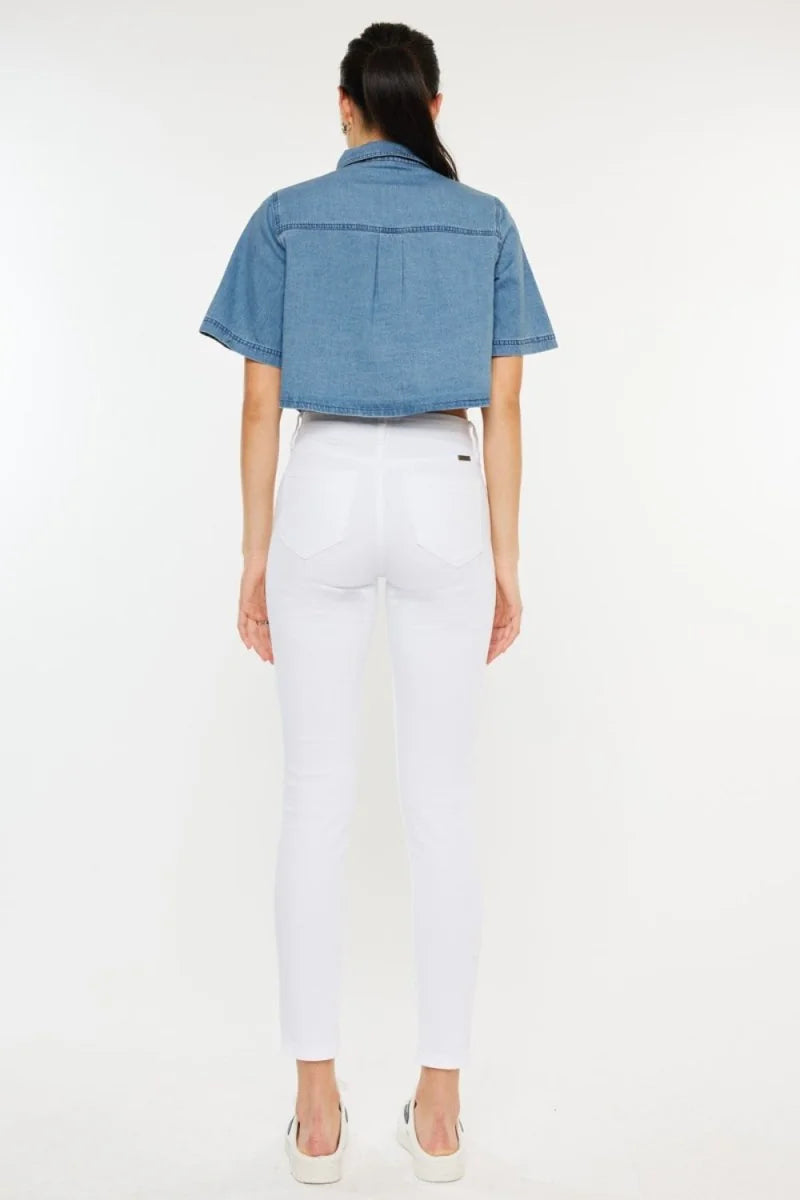 Woman from back wearing white skinny jeans and a blue denim cropped short-sleeve top.