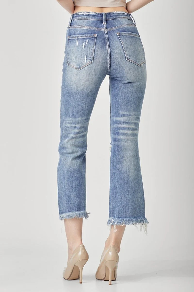 Distressed light wash denim jeans with frayed hem and moderate stretch.