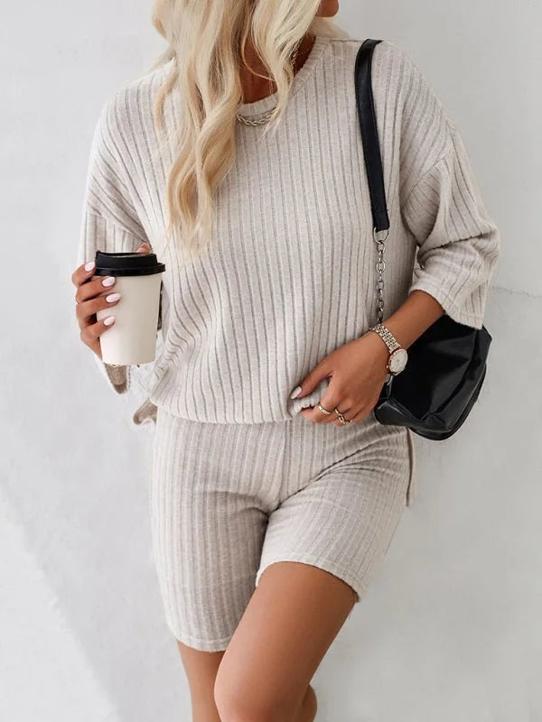 Beige ribbed knit loungewear set on model, showing short sleeves, crew neck, and biker shorts.