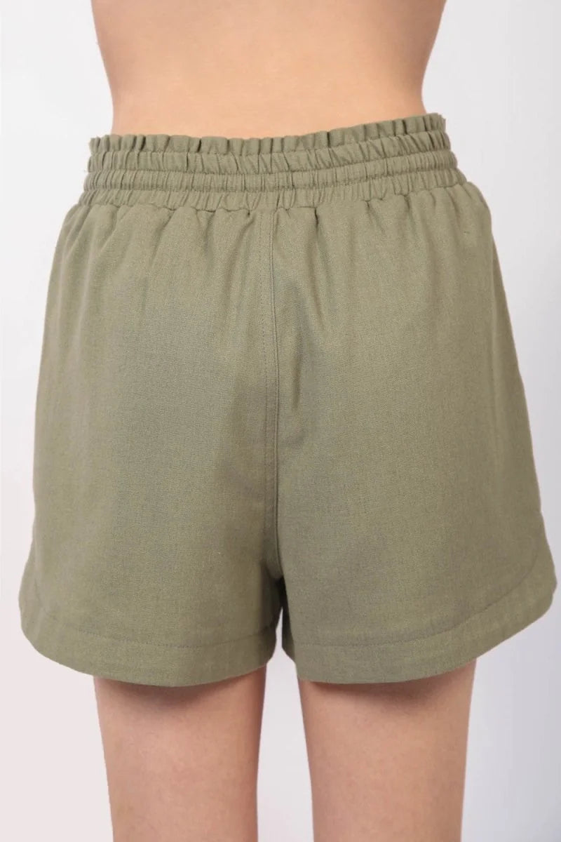 Back view of olive green linen-blend shorts with an elastic waistband and a relaxed fit.