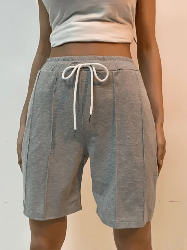 Grey knit shorts with drawstring waist and vertical seam details, on model.