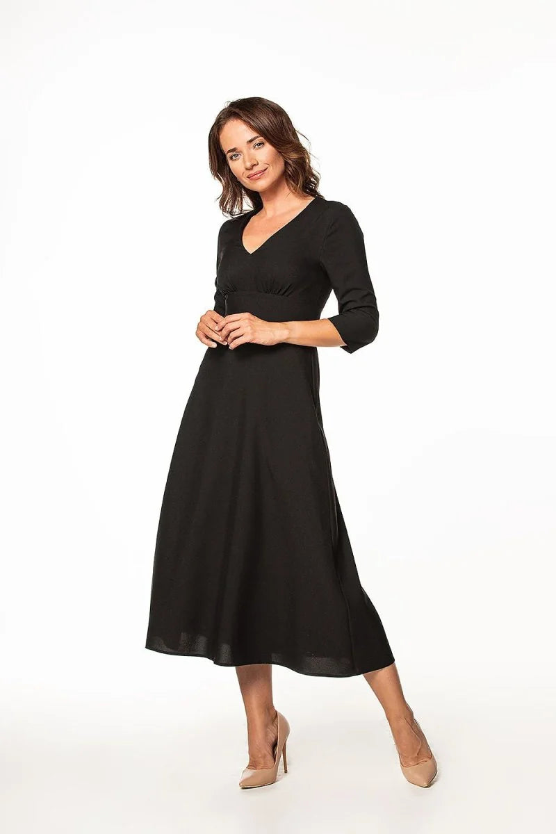 Black V-neck midi dress with 3/4 sleeves and empire waist, worn by a model.