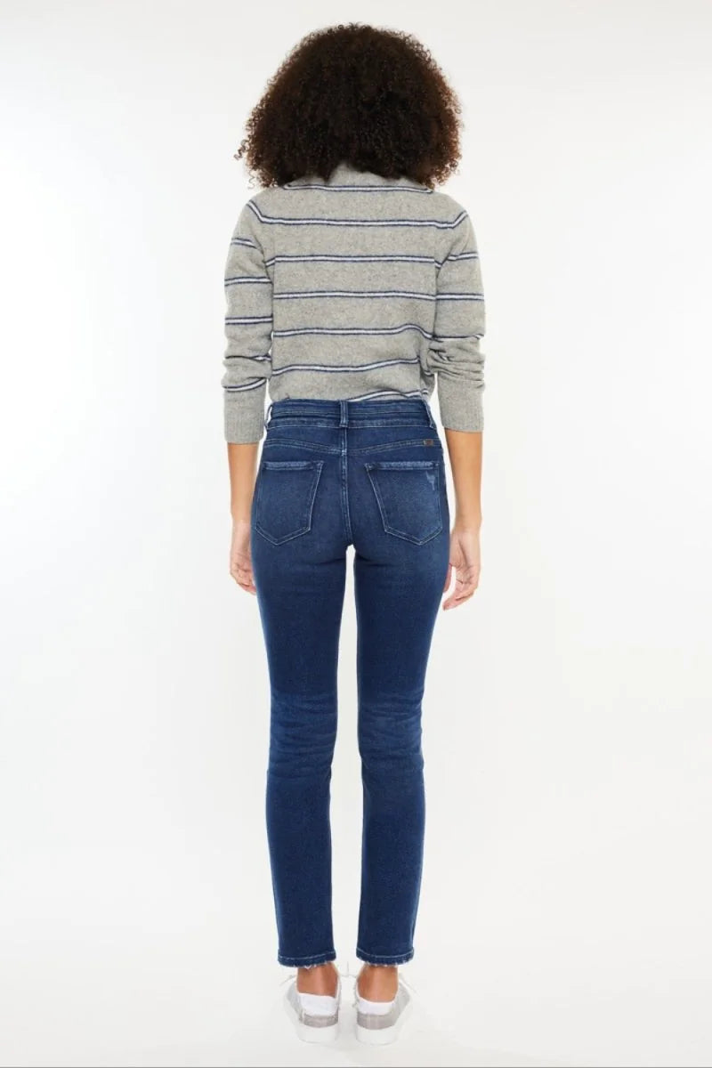 Close-up of the raw hem on dark wash jeans